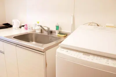 a white kitchen with a sink and a dishwasher at SunRiseStay Shibuya\u6da9\u8c37 in Tokyo