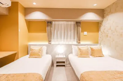 a hotel room with two beds and a window at Premium Apartment Hotel Tokyo Shinjuku in Tokyo