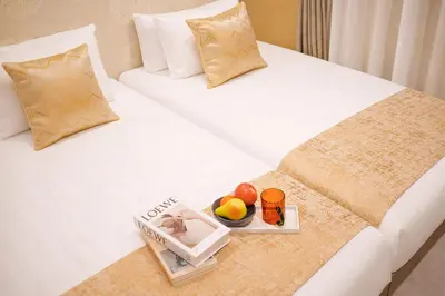 two beds in a hotel room with a tray of fruit at Premium Apartment Hotel Tokyo Shinjuku in Tokyo