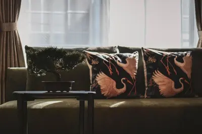 a couch with pillows and a table in a living room at Premium Apartment Hotel Tokyo Shinjuku in Tokyo