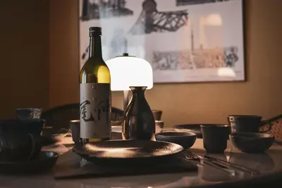 a bottle of wine and a plate on a table at Premium Apartment Hotel Tokyo Shinjuku in Tokyo