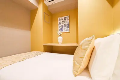 a bedroom with a bed with a vase on it at Premium Apartment Hotel Tokyo Shinjuku in Tokyo