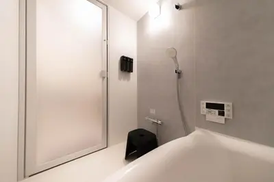 a bathroom with a shower with a mirror and a toilet at HOTEL Edogawa in Tokyo