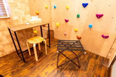 a room with a rock wall with a chair at 3 min walk from Sangenjaya Sta, 90square meters, Bouldering in Tokyo