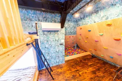 a room with a rock climbing wall and a ladder at 3 min walk from Sangenjaya Sta, 90square meters, Bouldering in Tokyo