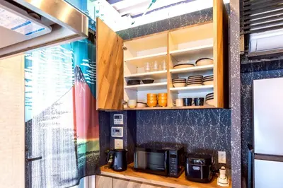 a kitchen with wooden cabinets and a microwave at 3 min walk from Sangenjaya Sta, 90square meters, Bouldering in Tokyo