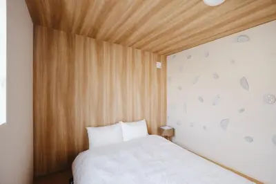 a bedroom with a bed with a wooden ceiling at \u672c\u753a3b\u30db\u30c6\u30eb in Tokyo
