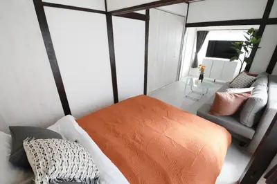 a bedroom with an orange bed and a couch at \u56db\u3064\u6728\u6238\u5efa2165 in Tokyo