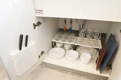 a kitchen with glasses and plates on a shelf at \u56db\u3064\u6728\u6238\u5efa2165 in Tokyo