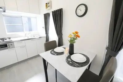 a kitchen with a table and a clock on the wall at \u56db\u3064\u6728\u6238\u5efa2165 in Tokyo