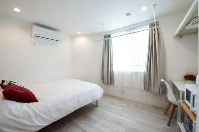 a white bedroom with a bed and a window at Boa Sorte Hotel AD0515 in Tokyo