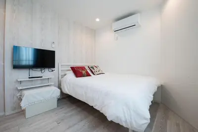 a bedroom with a bed and a flat screen tv at Boa Sorte Hotel AD0515 in Tokyo
