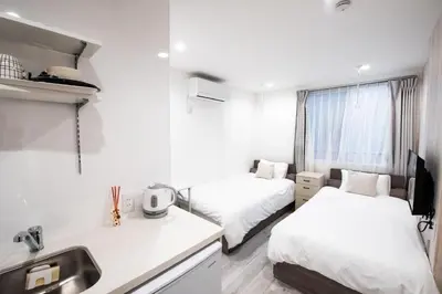 a white room with two beds and a sink at Boa Sorte Hotel AD0515 in Tokyo