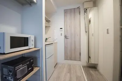 a small kitchen with a microwave and a refrigerator at Boa Sorte Hotel AD0515 in Tokyo
