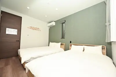 two beds sitting next to each other in a bedroom at NY Hotel Premium 1 \u65b0\u5bbf2\u968e\u5efa\u30663\u5ba41\u30d0\u30b9\u30eb\u30fc\u30e01\u30b7\u30e3\u30ef\u30fc2\u30c8\u30a4\u30ec in Tokyo