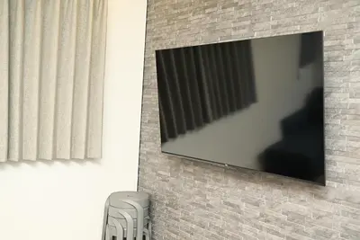 a flat screen tv hanging on a brick wall at NY Hotel Premium 1 \u65b0\u5bbf2\u968e\u5efa\u30663\u5ba41\u30d0\u30b9\u30eb\u30fc\u30e01\u30b7\u30e3\u30ef\u30fc2\u30c8\u30a4\u30ec in Tokyo