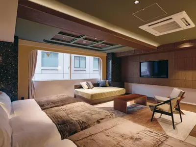 a bedroom with a bed and a couch and a tv at illi Eme Tokyo-Toranomon in Tokyo