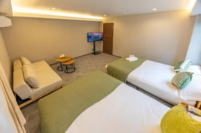 a hotel room with two beds and a flat screen tv at Sunny hotel 2 min walk to Iriya Station Direct to Ueno and Asakusa in Tokyo