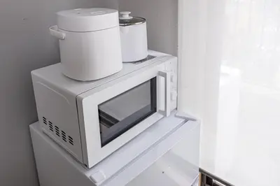 a microwave with two cups on top of it at Sunny hotel 2 min walk to Iriya Station Direct to Ueno and Asakusa in Tokyo