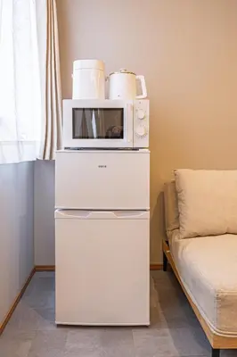 a microwave sitting on top of two white drawers at Sunny hotel 2 min walk to Iriya Station Direct to Ueno and Asakusa in Tokyo