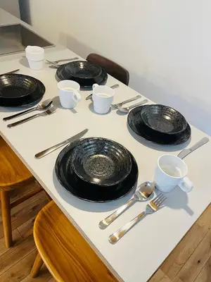 a table with black plates and utensils on it at mtk\u6238\u8d8a3\u4e01\u76ee01 in Tokyo