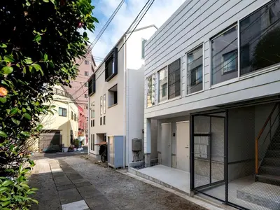 an empty alley in a city with buildings at mtk\u6238\u8d8a3\u4e01\u76ee01 in Tokyo