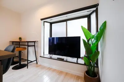 a living room with a large window with a flat screen tv at Yuka's House Otsuka Perfect for children in Tokyo