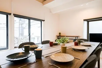 a dining room table with plates and utensils on it at Yuka's House Otsuka Perfect for children in Tokyo