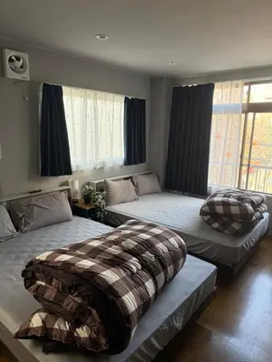 two beds sitting in a room with windows at The Asakusa Townhouse in Tokyo