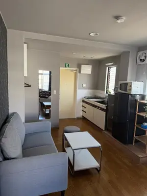 a living room with a couch and a kitchen at The Asakusa Townhouse in Tokyo