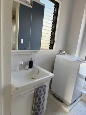 a white bathroom with a sink and a mirror at The Asakusa Townhouse in Tokyo