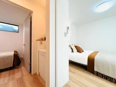a bedroom with a bed and a bathroom with a mirror at Lulu House 3BDR Room! Near Skytree in Tokyo