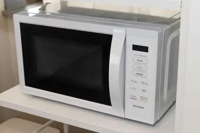 a white microwave oven sitting on a white counter at Y's Hotel in Tokyo