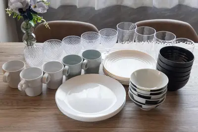 a table with plates and cups and a vase with flowers at Y's Hotel in Tokyo