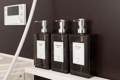 a group of three perfume bottles on a shelf at Y's Hotel in Tokyo