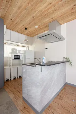 a kitchen with a stainless steel counter and wooden ceilings at Y's Hotel in Tokyo