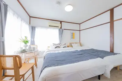 a bedroom with a large bed and a table at Tokyo Ikebukuro House in Tokyo