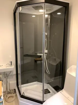 a glass shower in a bathroom next to a sink at Tokyo Ikebukuro House in Tokyo