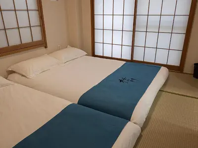 a bedroom with two beds and two windows at \u685c\u306e\u5ddd78 \u5317\u5343\u4f4f\u4e00\u6237\u5efa6-8\u4eba\u4e28Kita Senju villa for 6-8 people in Tokyo