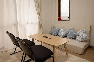 a living room with a table and a couch at \u685c\u306e\u5ddd78 \u5317\u5343\u4f4f\u4e00\u6237\u5efa6-8\u4eba\u4e28Kita Senju villa for 6-8 people in Tokyo