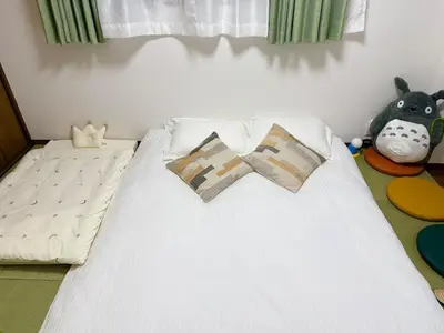 a white bed with two pillows and a stuffed animal at IITaito area,3 people,3-minute to station, 2-tatami beds,family type in Tokyo