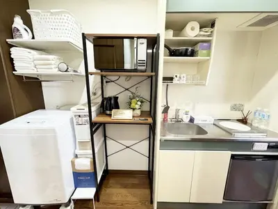 a small kitchen with a sink and a microwave at IITaito area,3 people,3-minute to station, 2-tatami beds,family type in Tokyo