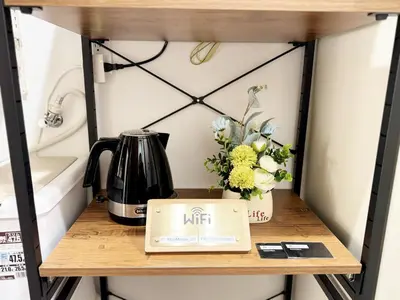 a table with a laptop on a shelf with flowers at SIMMONS Brand beds,3 mins walk to station,,Ueno area,Direct to Akihabara 8 mins,Ginza 24 mins in Tokyo