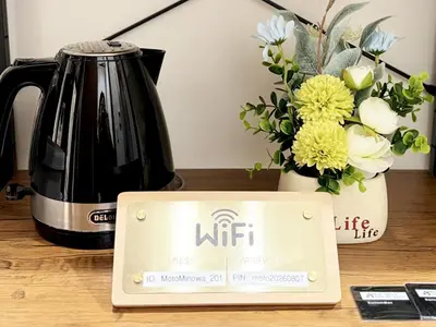 a coffee pot and a sign on a counter with flowers at SIMMONS Brand beds,3 mins walk to station,,Ueno area,Direct to Akihabara 8 mins,Ginza 24 mins in Tokyo