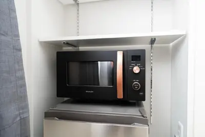 a microwave oven on a shelf in a kitchen at Alice \u6696\u5c4b \u845b\u9970\u533a\u6e29\u99a8\u516c\u5bd3 \u6b65\u884c2\u5206\u949f\u5230\u8f66\u7ad9 \u673a\u573a\u4ea4\u901a\u4fbf\u5229 \u6700\u591a4\u4eba in Tokyo