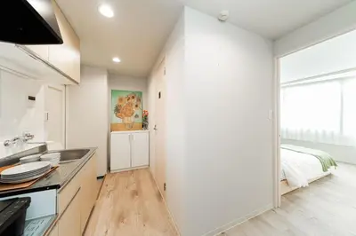 a white kitchen with a sink and a bed at Alice \u6696\u5c4b \u845b\u9970\u533a\u6e29\u99a8\u516c\u5bd3 \u6b65\u884c2\u5206\u949f\u5230\u8f66\u7ad9 \u673a\u573a\u4ea4\u901a\u4fbf\u5229 \u6700\u591a4\u4eba in Tokyo