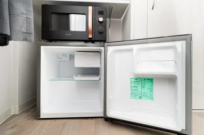 an open refrigerator with a microwave on top of it at Alice \u6696\u5c4b \u845b\u9970\u533a\u6e29\u99a8\u516c\u5bd3 \u6b65\u884c2\u5206\u949f\u5230\u8f66\u7ad9 \u673a\u573a\u4ea4\u901a\u4fbf\u5229 \u6700\u591a4\u4eba in Tokyo