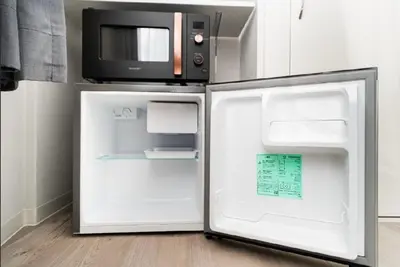 an open refrigerator with a microwave on top of it at Alice \u6696\u5c4b \u845b\u9970\u533a\u6e29\u99a8\u516c\u5bd3 \u6b65\u884c2\u5206\u949f\u5230\u8f66\u7ad9 \u673a\u573a\u4ea4\u901a\u4fbf\u5229 \u6700\u591a4\u4eba in Tokyo