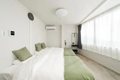a white bedroom with a large bed and a window at Alice \u6696\u5c4b \u845b\u9970\u533a\u6e29\u99a8\u516c\u5bd3 \u6b65\u884c2\u5206\u949f\u5230\u8f66\u7ad9 \u673a\u573a\u4ea4\u901a\u4fbf\u5229 \u6700\u591a4\u4eba in Tokyo