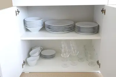 a white cabinet filled with plates and bowls and glasses at \u6771\u967d\u753a\u99c5\u5f92\u6b695\u5206 \u6700\u59275\u540d \u30d5\u30a1\u30df\u30ea\u30fc\u5411\u3051 \u6771\u4eac\u99c510\u5206 \u30c7\u30a3\u30ba\u30cb\u30fc \u30b9\u30ab\u30a4\u30c4\u30ea\u30fc\u4fbf\u5229 in Tokyo